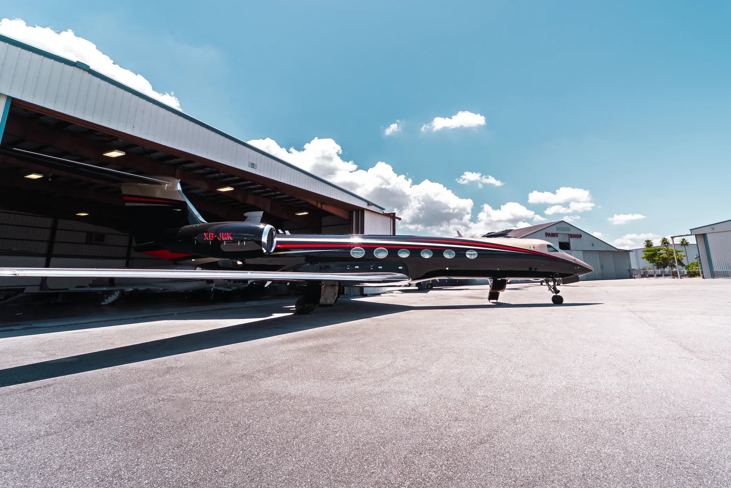 Side and rear view of the Gulfstream G550 exterior beside an airport hangar.