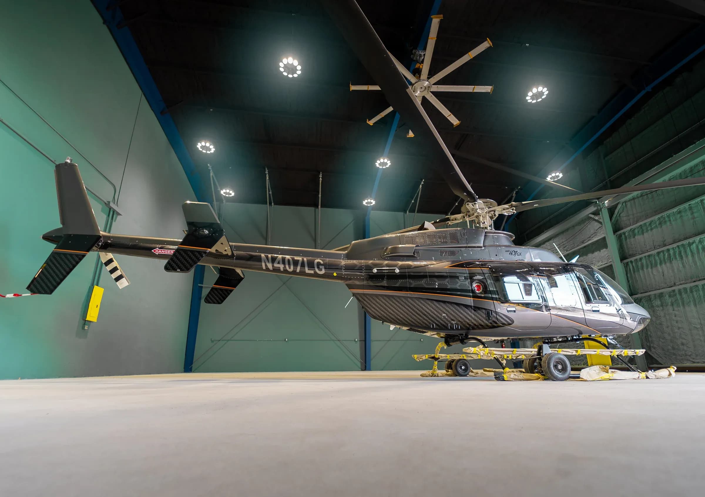 Rear-side exterior view of the Bell 407 inside a hangar.