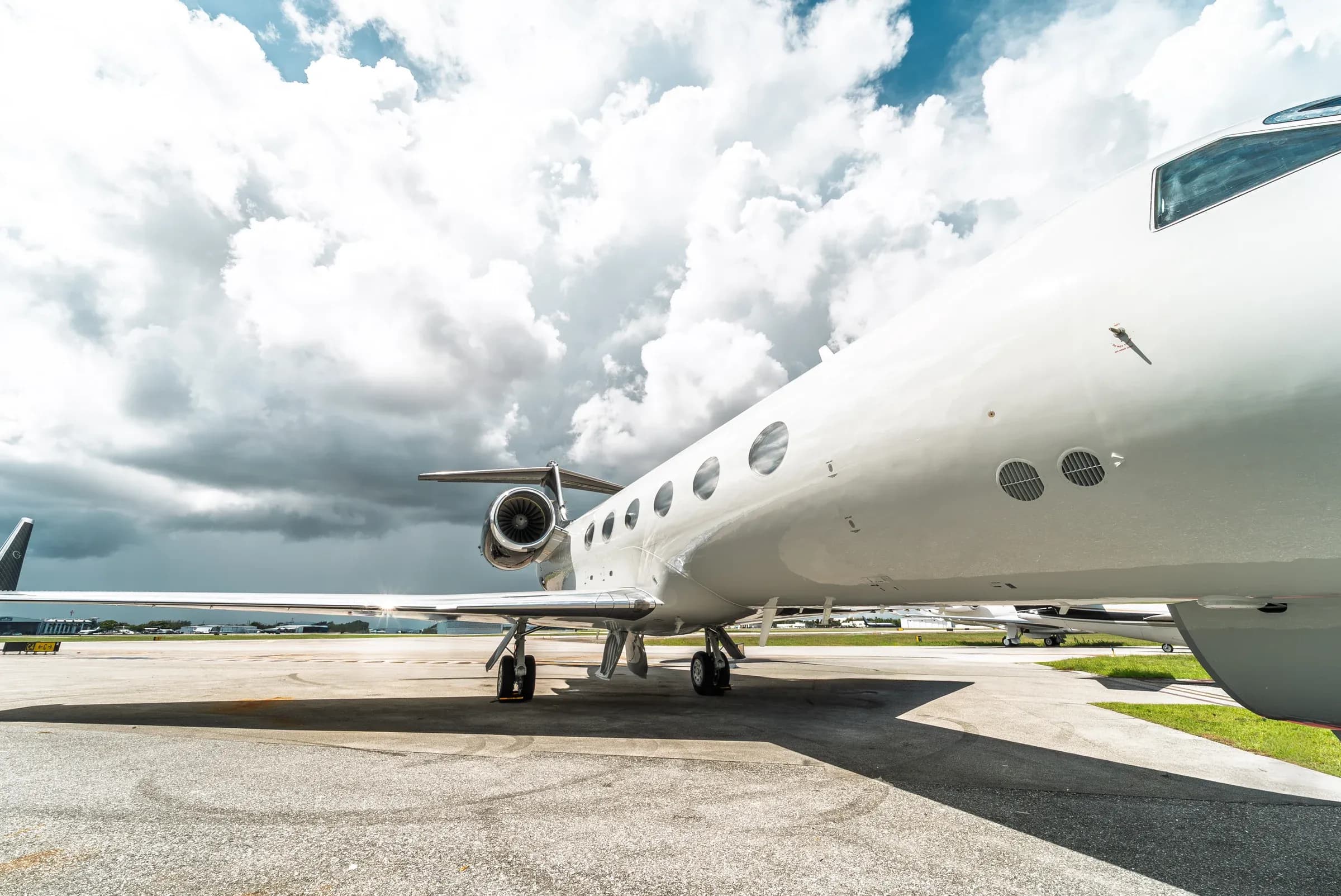 Low-angle side view of the Gulfstream G-IV fuselage under a blue sky.