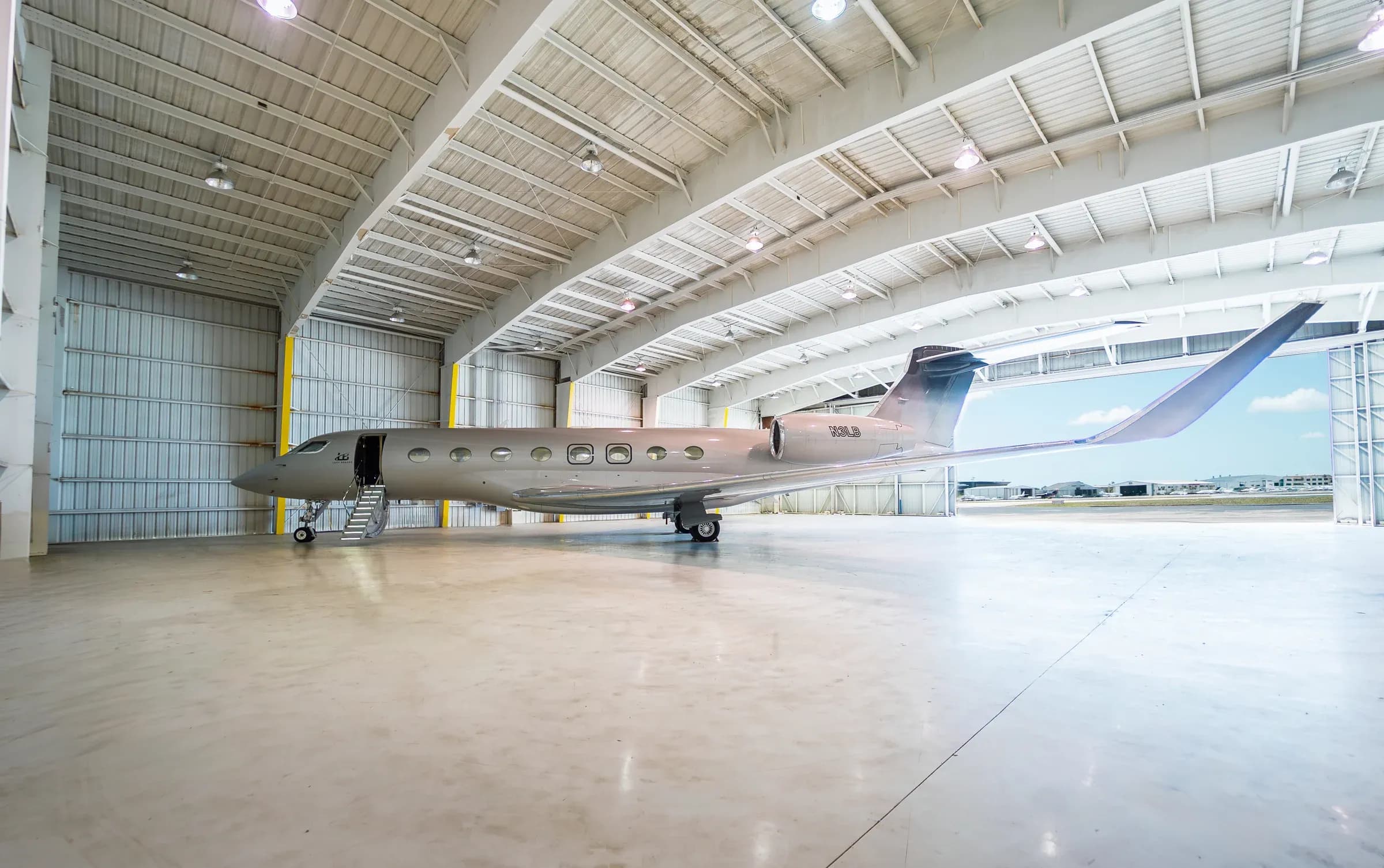 Full exterior view of the Gulfstream G650ER inside a bright aircraft hangar.