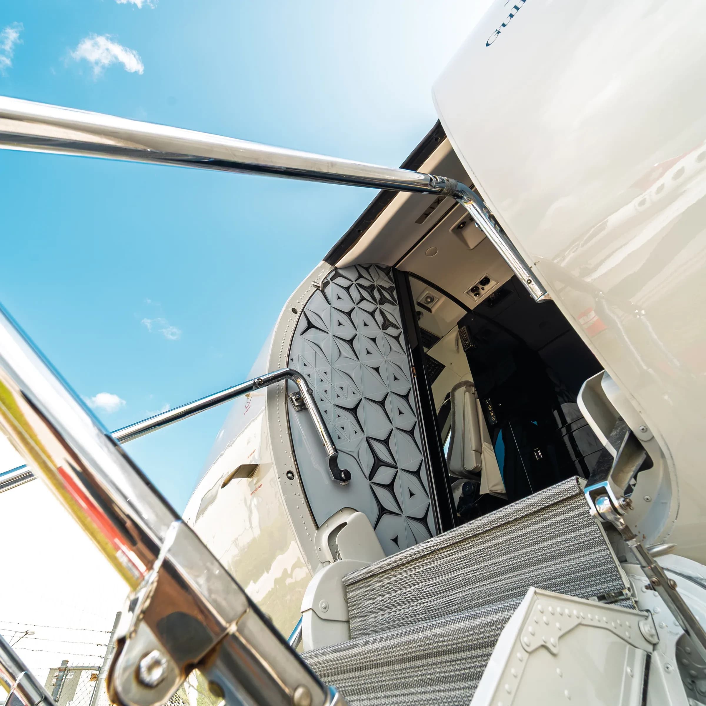 Gulfstream G-IV entry stairs and handrail beside a geometric entrance panel.