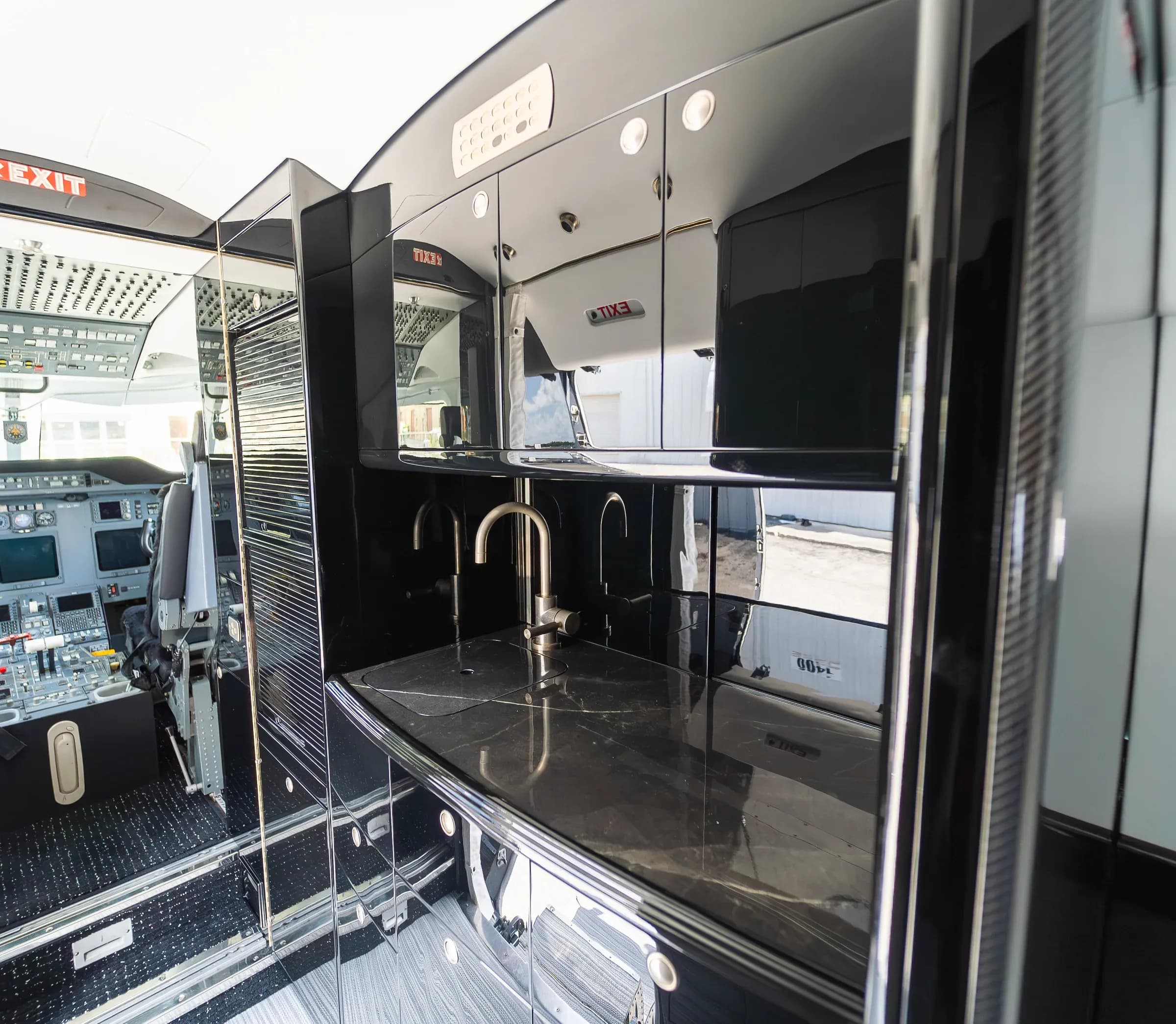 Gulfstream G200 galley with a countertop, sink and glossy dark cabinetry.