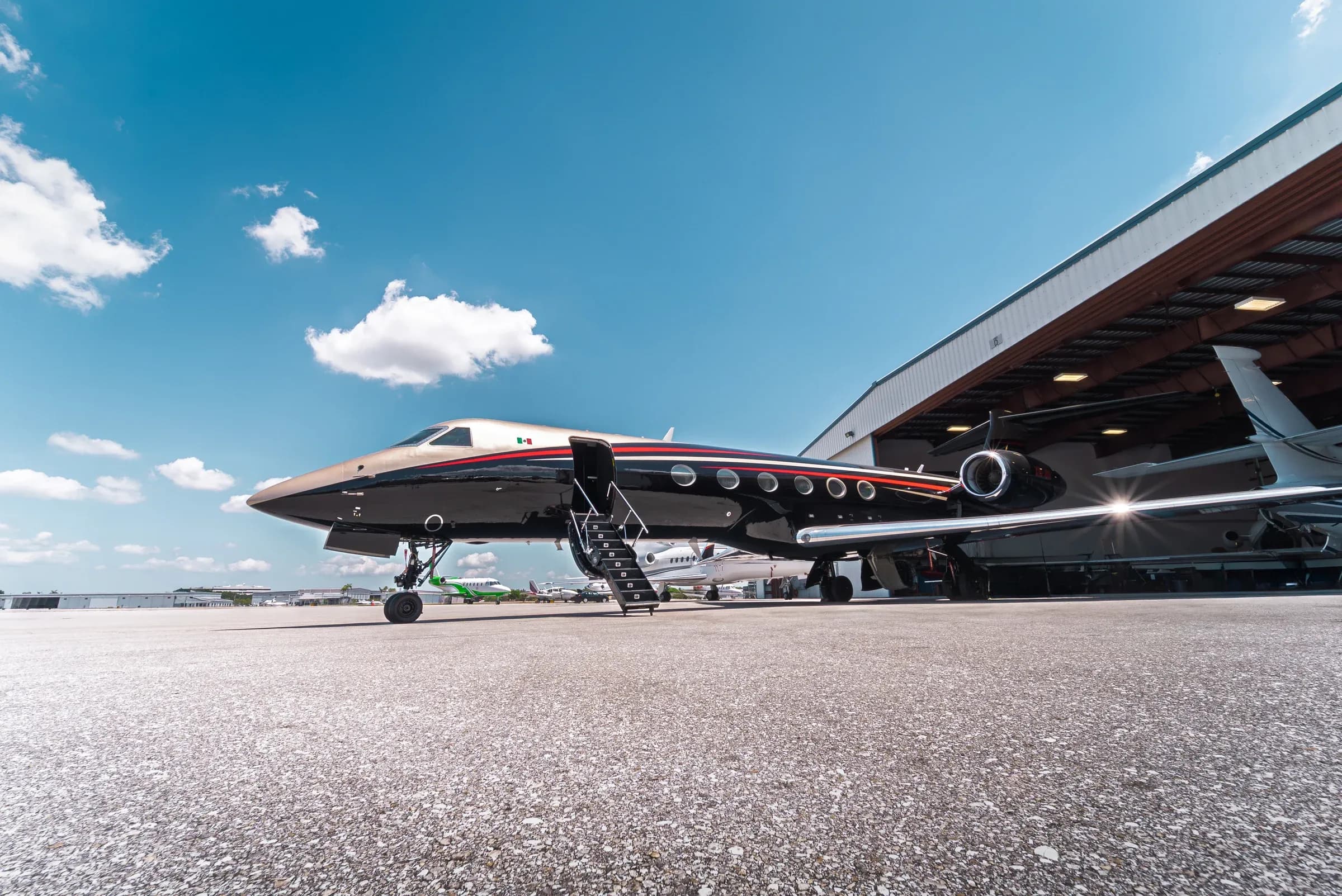 Low three-quarter view of the Gulfstream G550 exterior and open entry stairs.