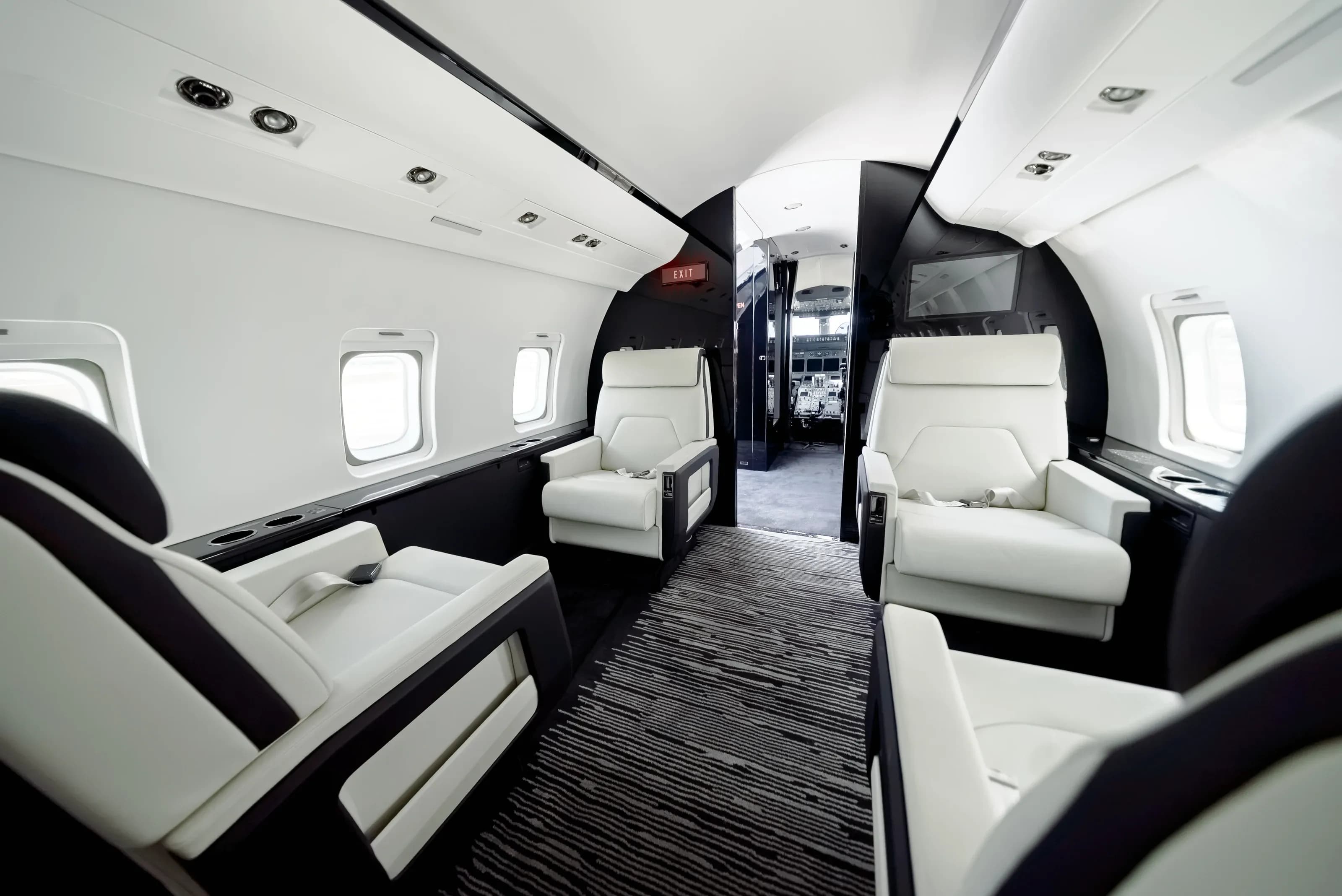 Wide Challenger 604 cabin view showing facing seating groups and the dark central partition.