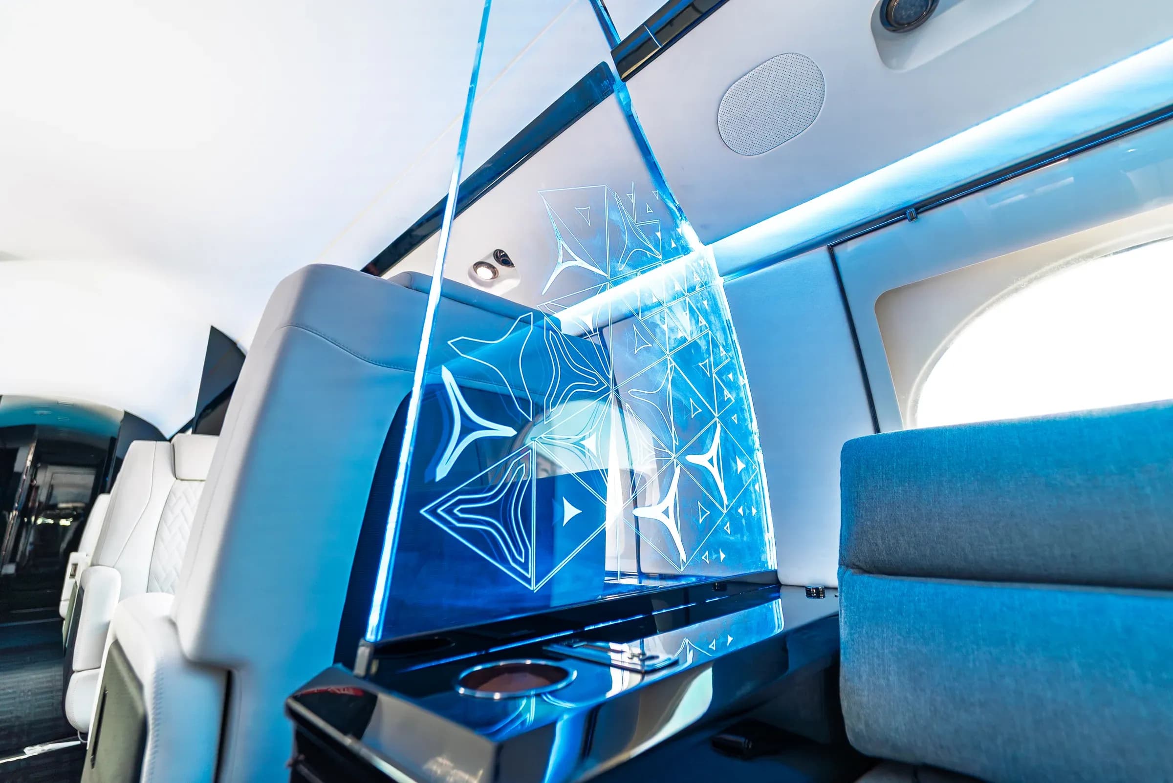 Illuminated geometric partition beside the blue Gulfstream G-IV divan.