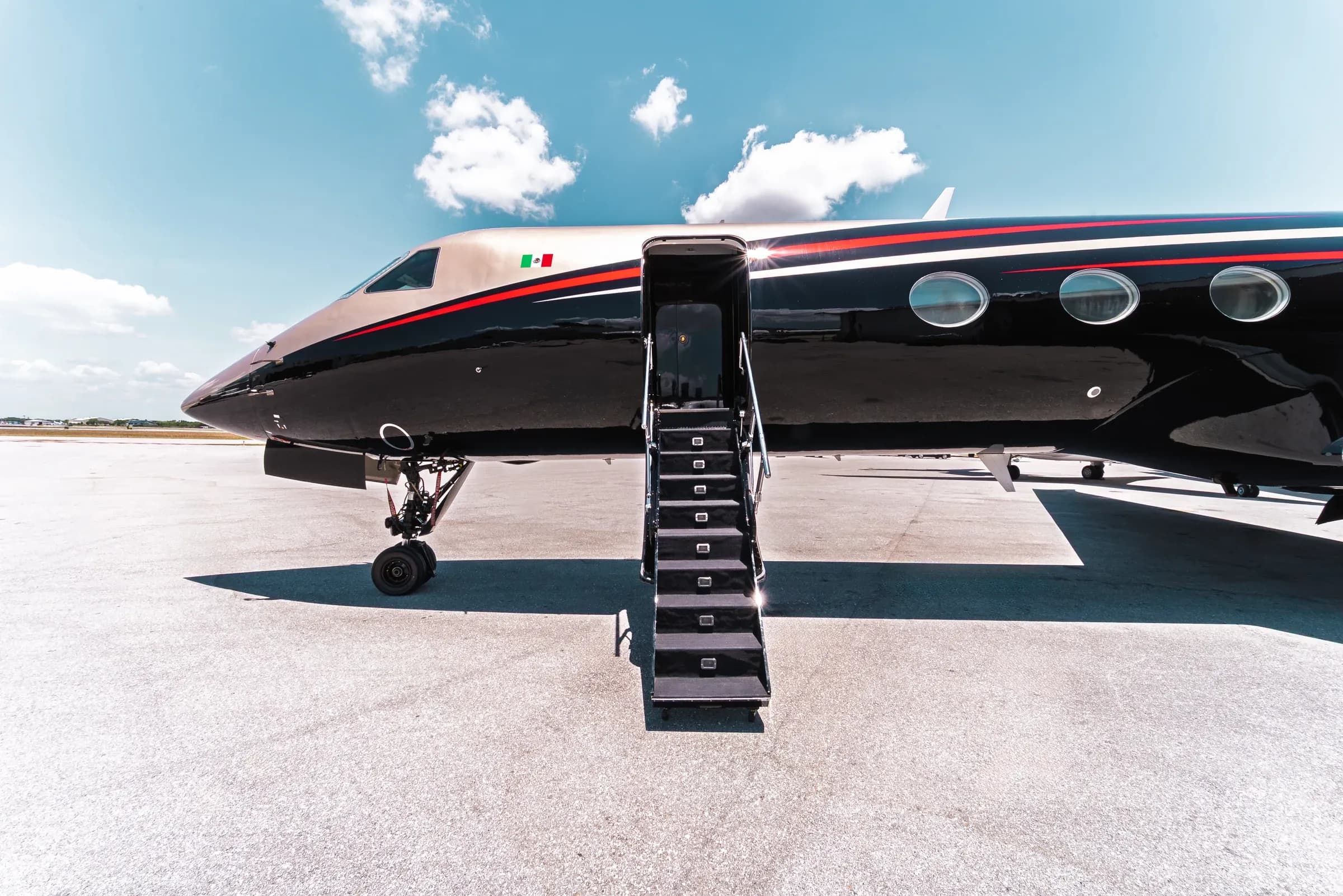 Gulfstream G550 open entry stairs and front fuselage in daylight.