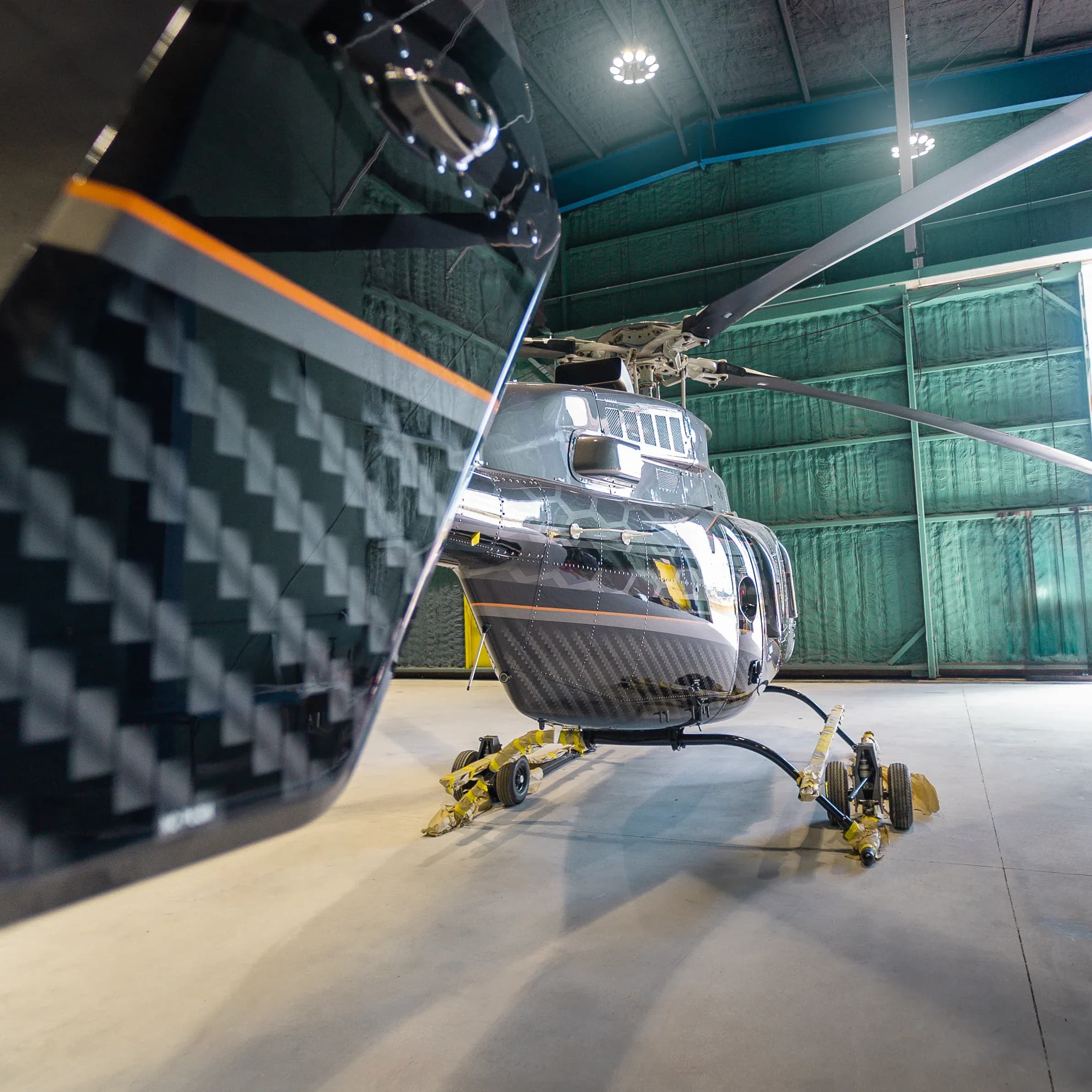 Close view of the Bell 407 woven-pattern open door panel with an orange accent.