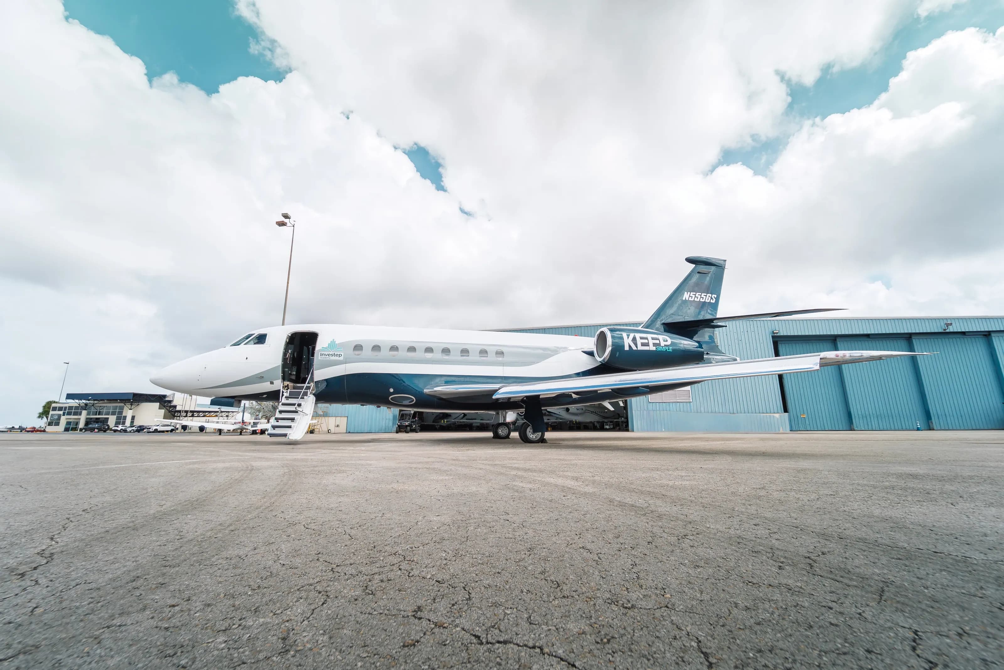 Side profile of the Falcon 2000 outside the hangar, with its cabin stairs extended.