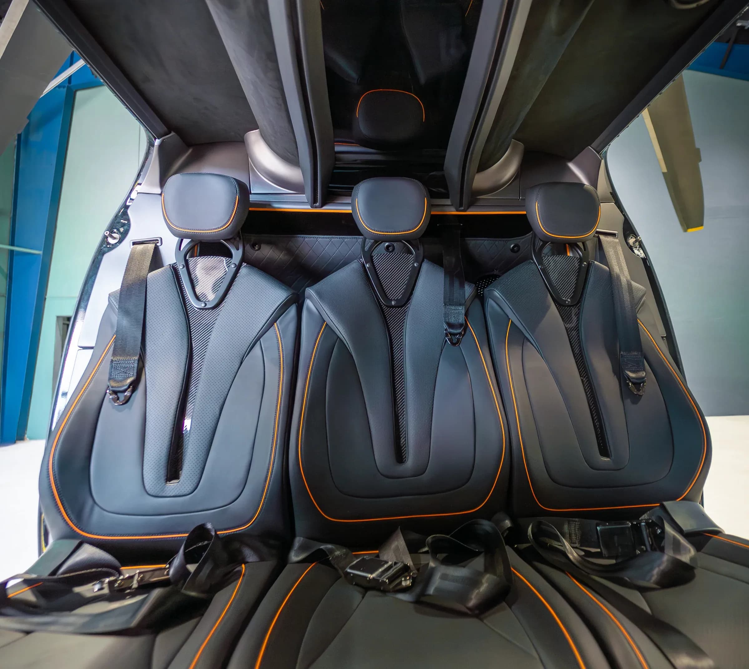 Front view of dark Bell 407 passenger seat backs with orange edging.