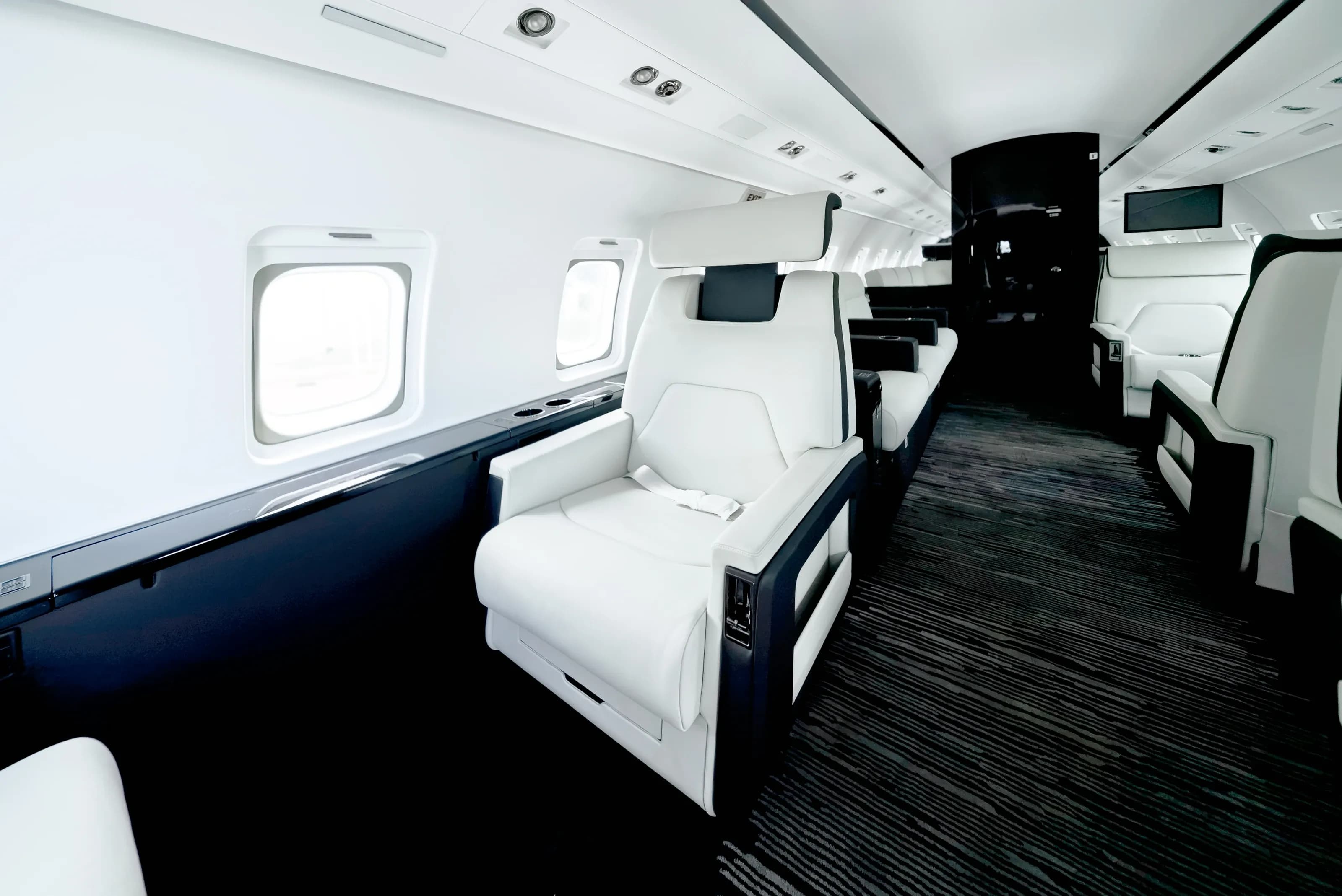 Challenger 604 window-side seating and the transition from ivory upholstery to dark cabinetry.