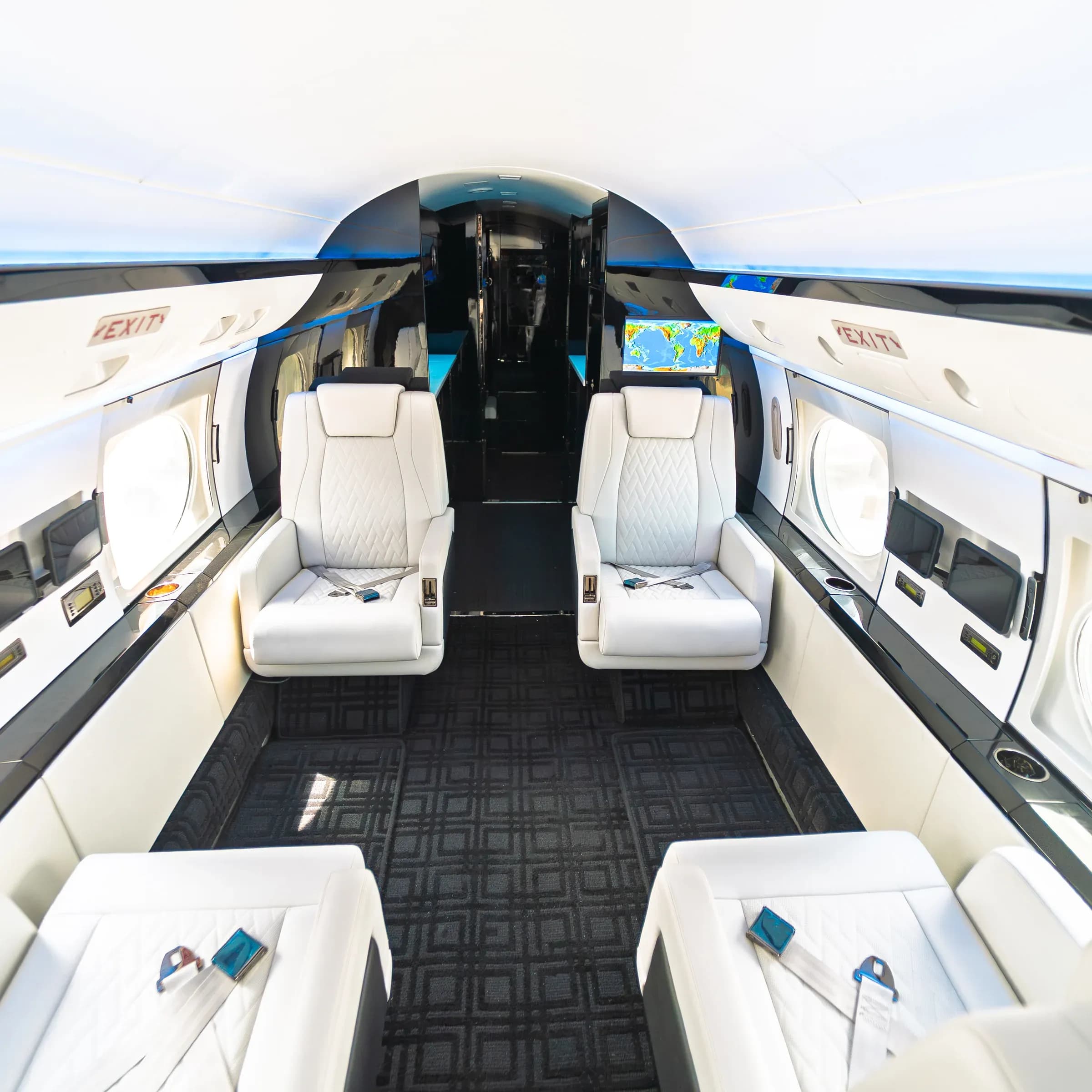 Centered Gulfstream G-IV cabin view with paired white seats and dark carpet.