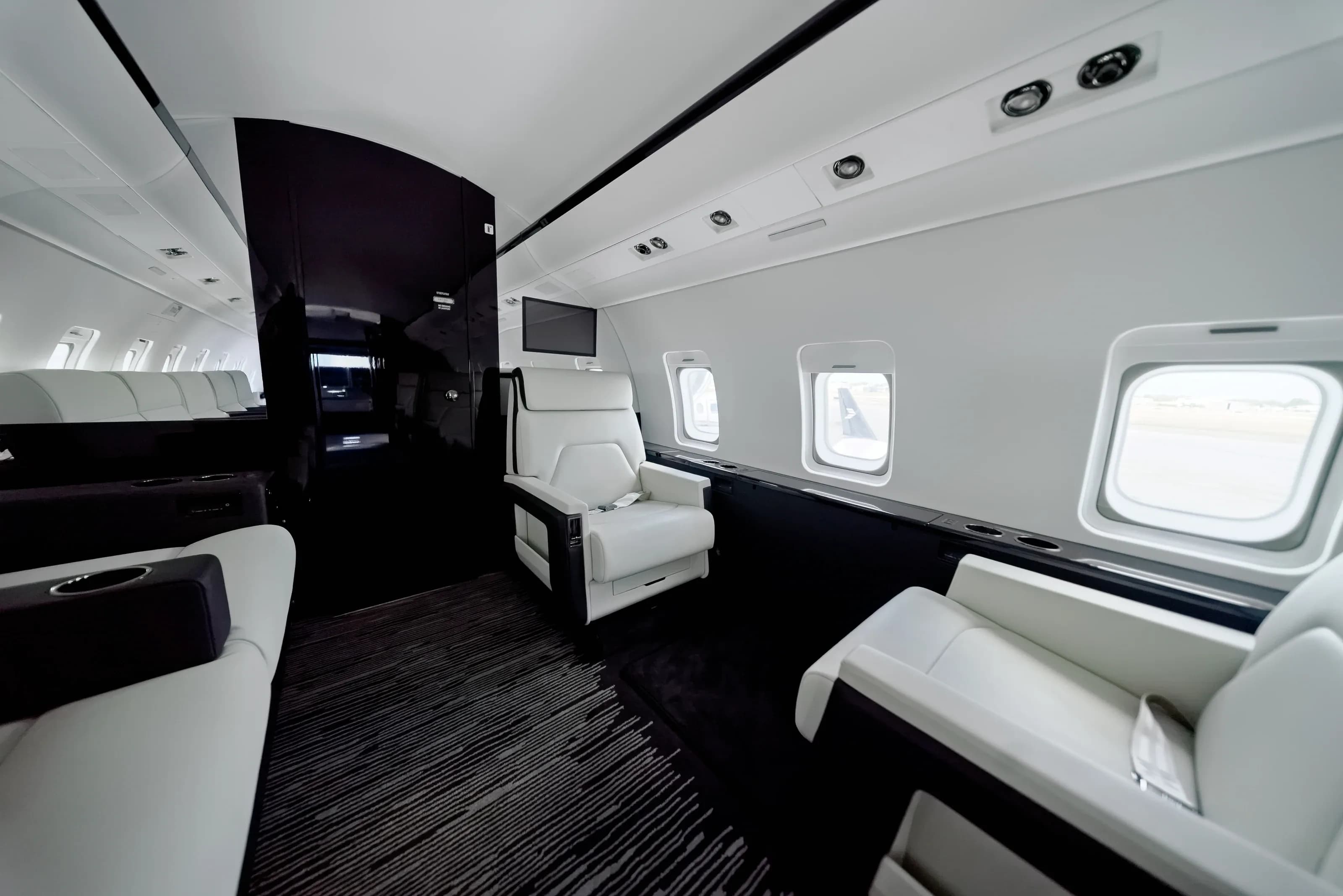 Challenger 604 aft seating and glossy dark cabinetry beside the cabin windows.