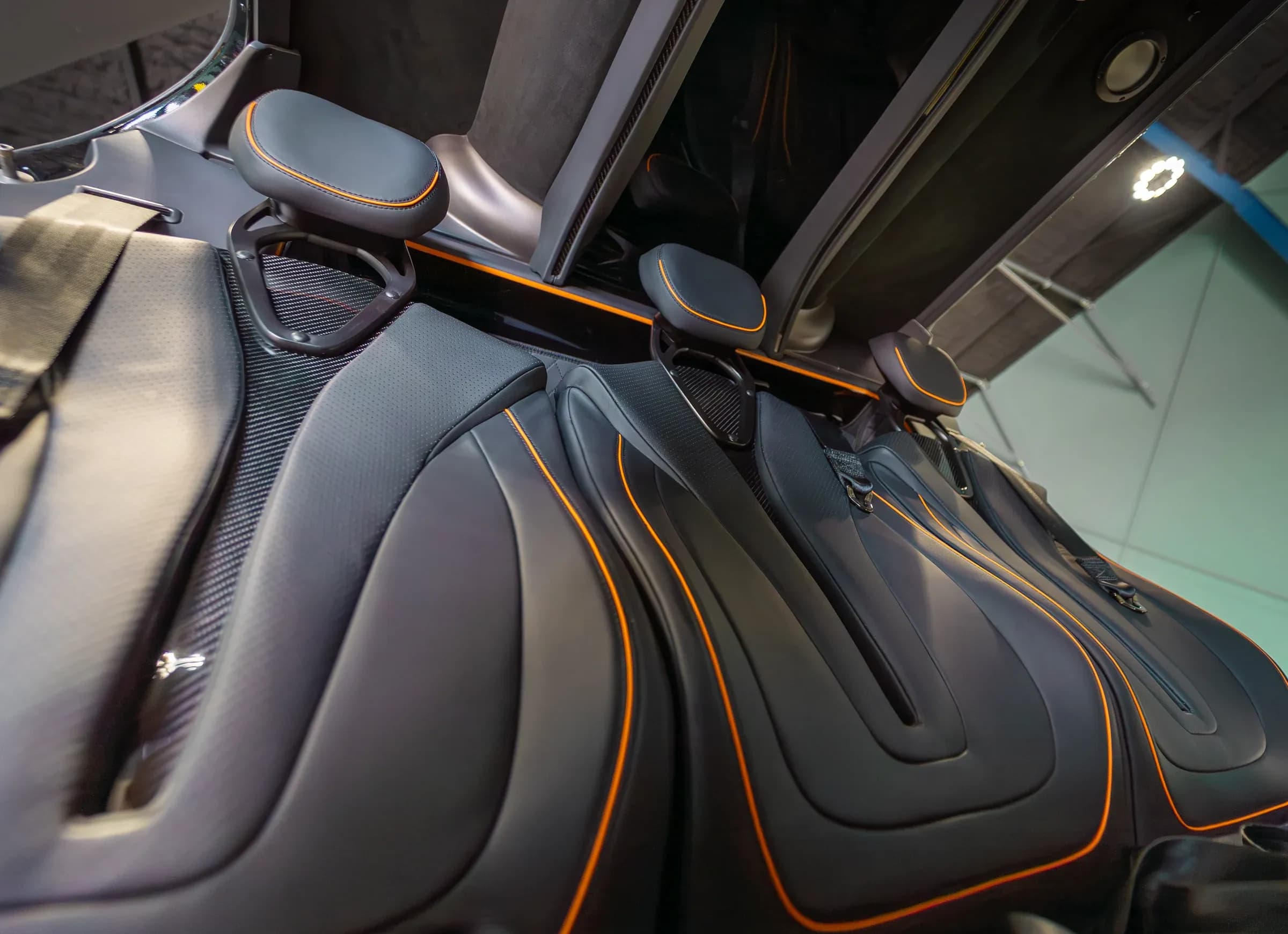 Angled view of Bell 407 passenger headrests and orange seat contours.