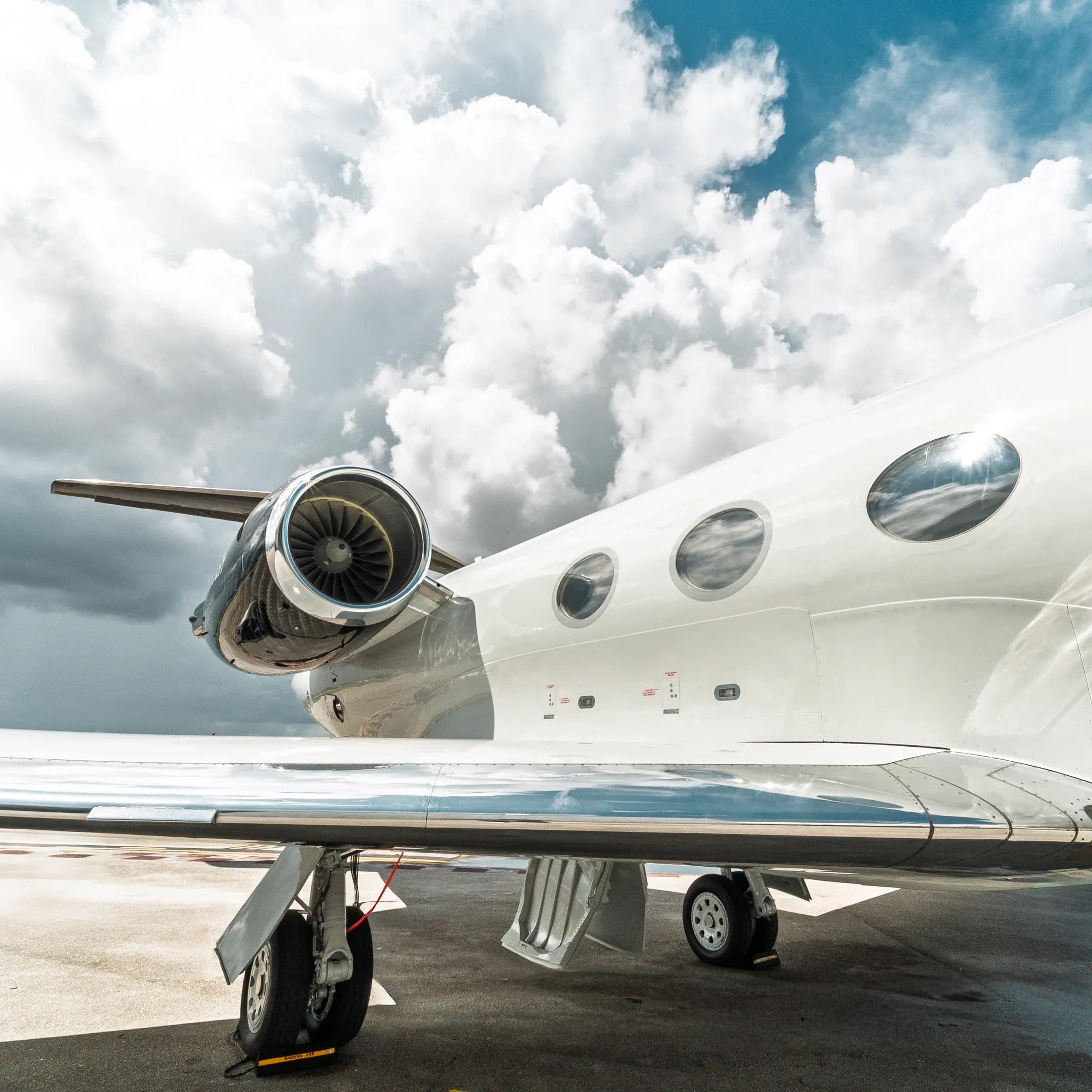 Rear section of the Gulfstream G-IV showing the engine and wing beneath clouds.