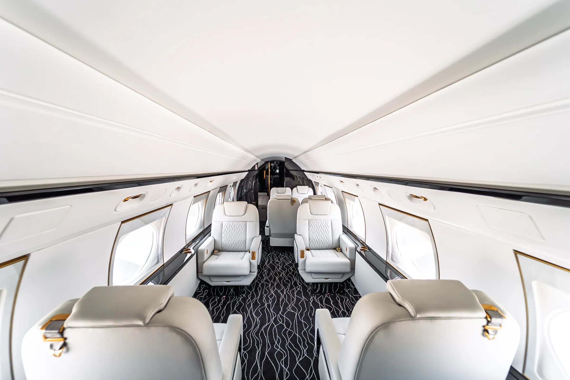 Elevated view along the Gulfstream G550 cabin above the foreground seat backs.