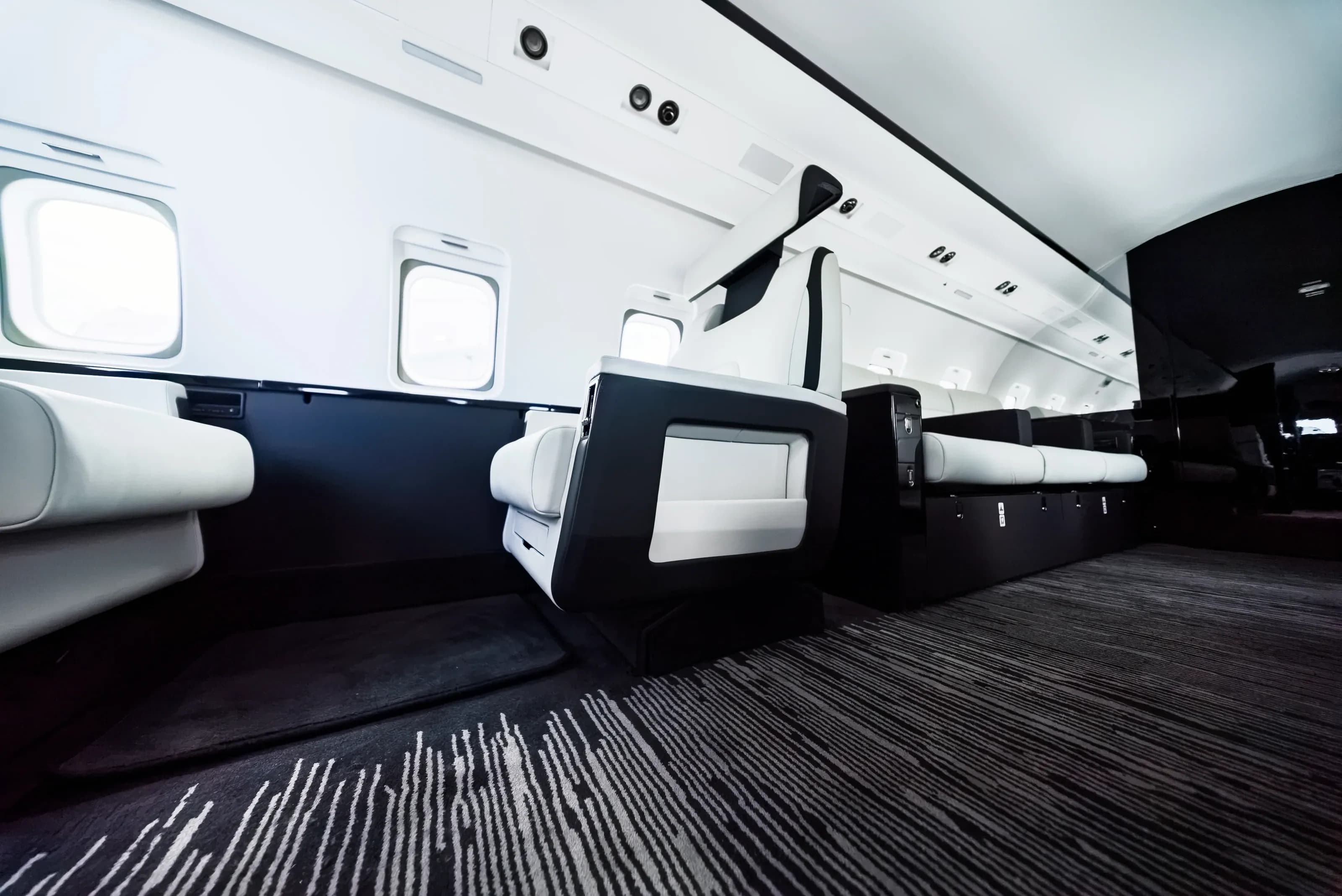 Challenger 604 seating, dark side ledge and patterned carpet viewed from floor level.