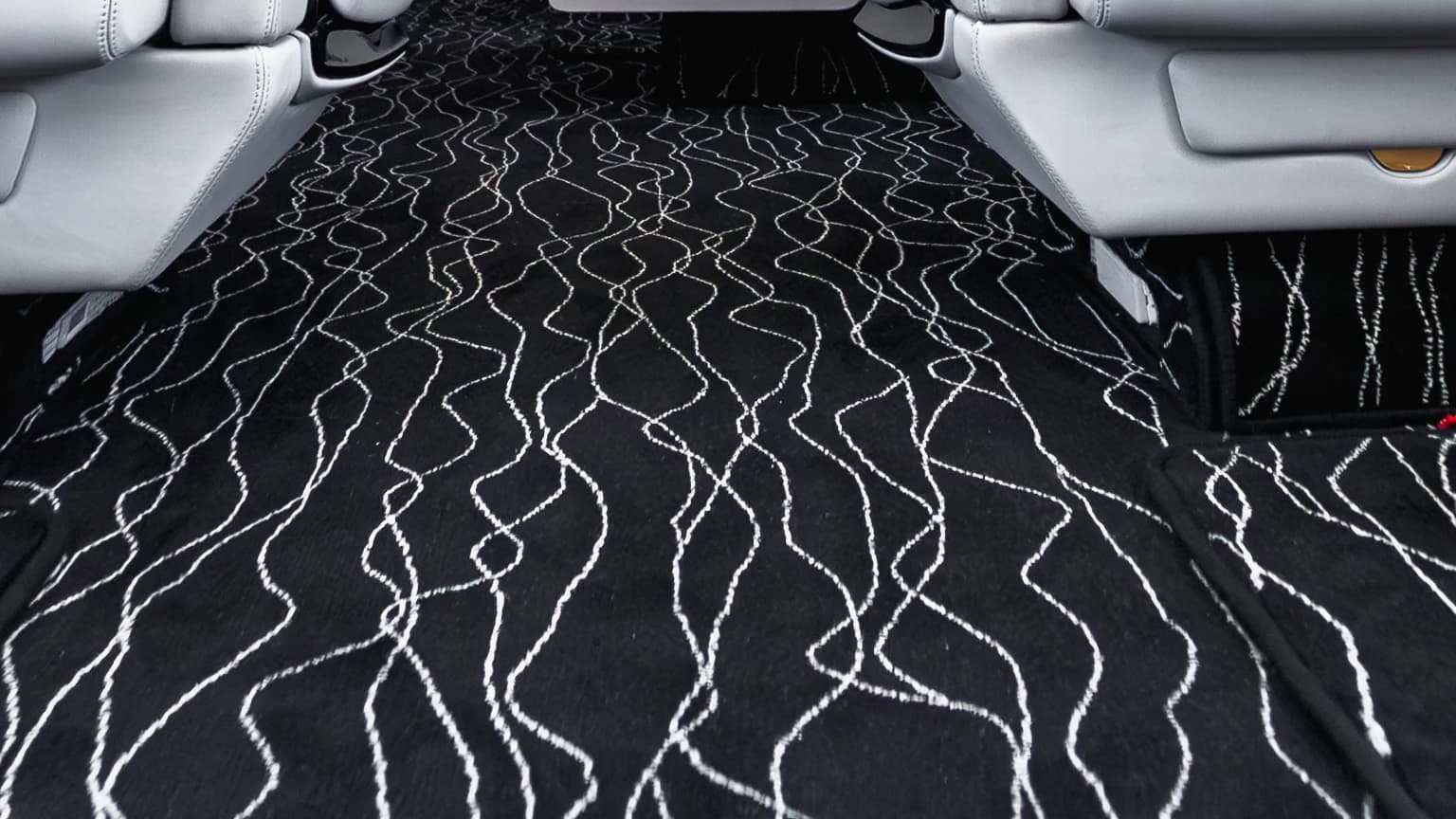 Close view of the original flowing light pattern across the Gulfstream G550 dark cabin carpet.