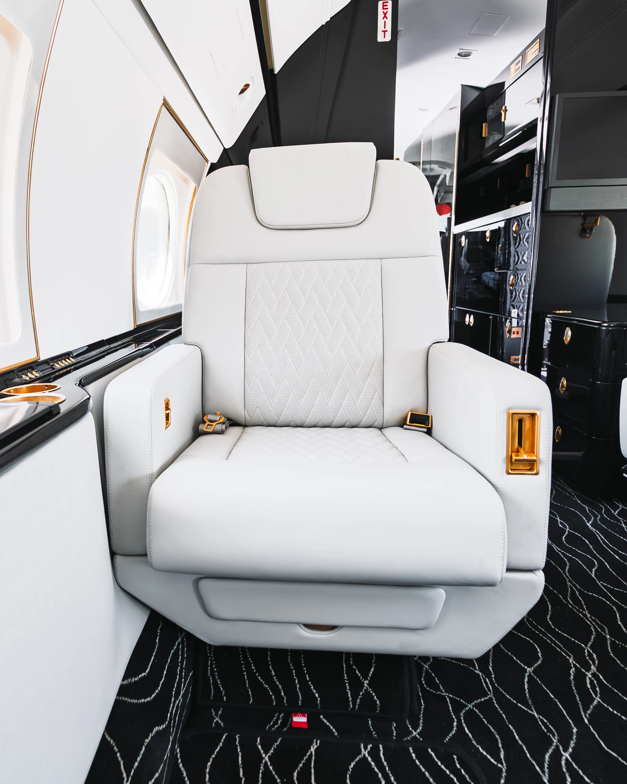 Gulfstream G550 ivory seat with its original quilted insert, gold-tone controls and dark surrounding trim.