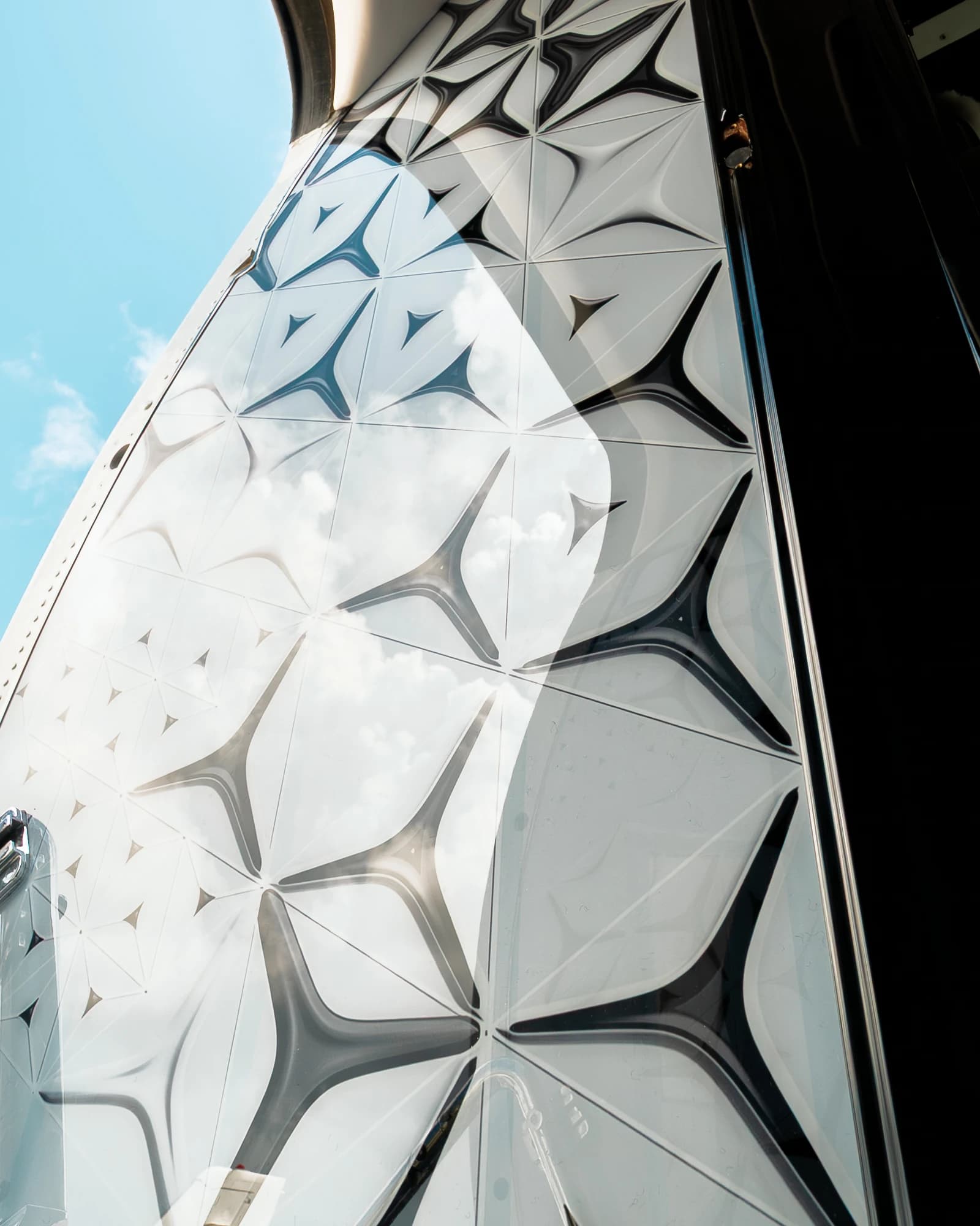 Original sculpted geometric entrance panel on the Gulfstream GIV, with daylight reflected across its surface.