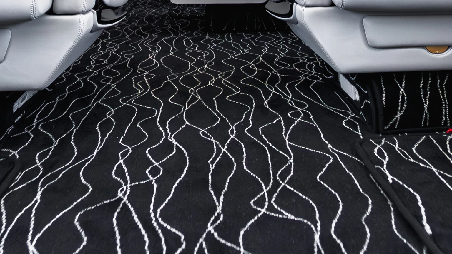 Close view of the original flowing light pattern across the Gulfstream G550 dark cabin carpet.