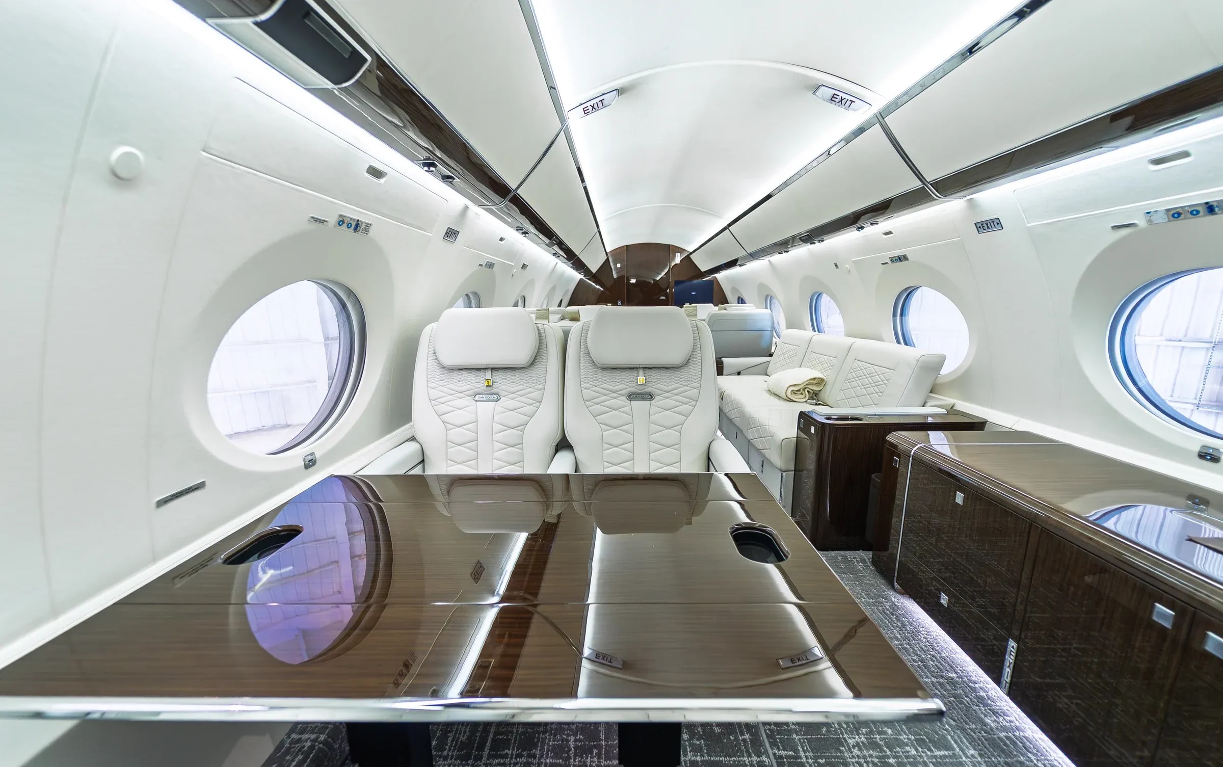 Glossy table in the foreground of the Gulfstream G650ER club seating area.