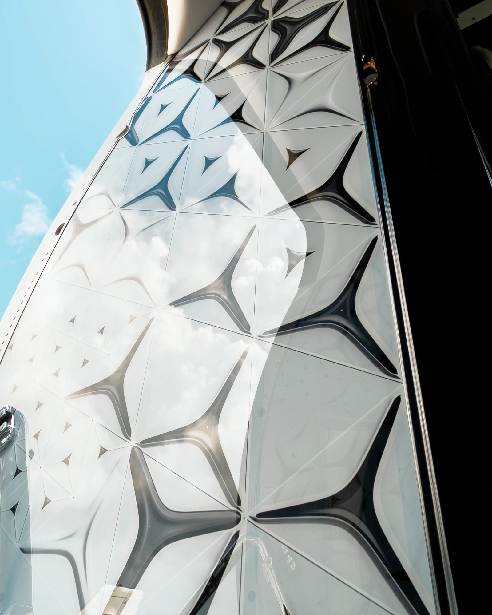 Original sculpted geometric entrance panel on the Gulfstream GIV, with daylight reflected across its surface.